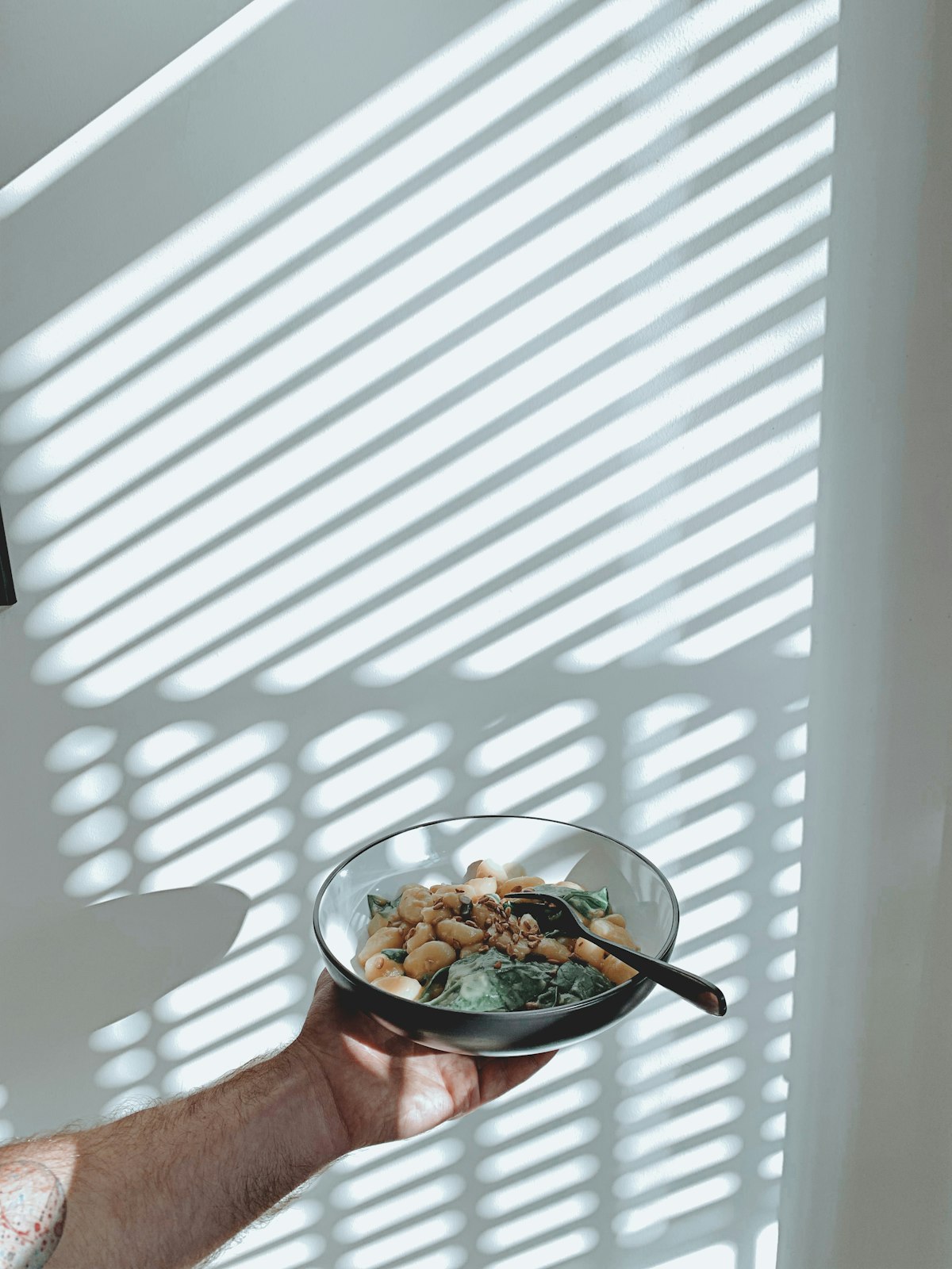A nourishing bowl held in striped sunlight